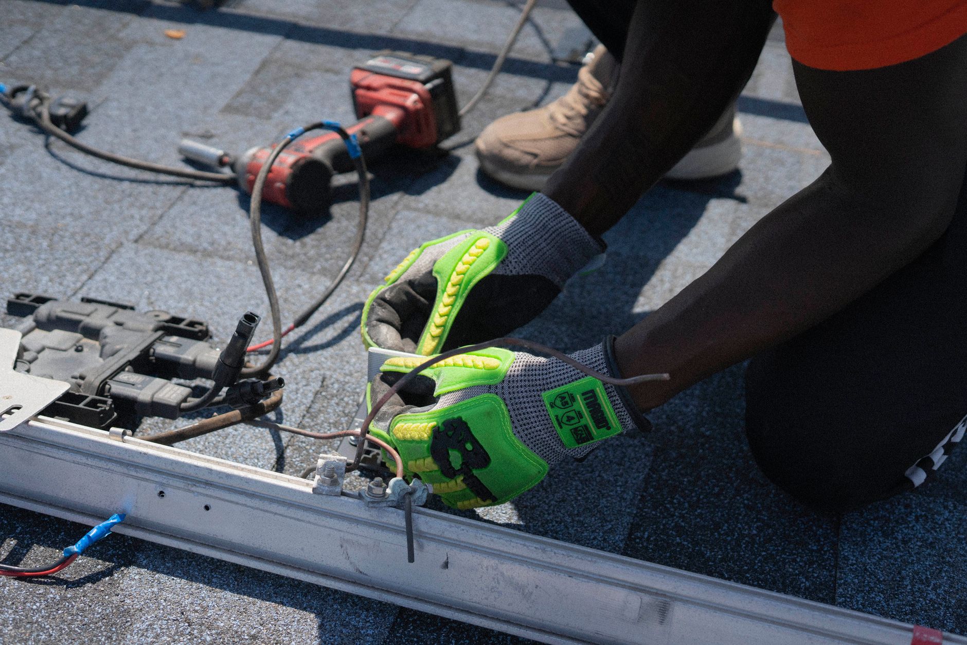 A GAF certified installer from Stone Ridge Roofing inspecting a roof on a multi-family home in Lynn, MA, with the ocean visible in the background.