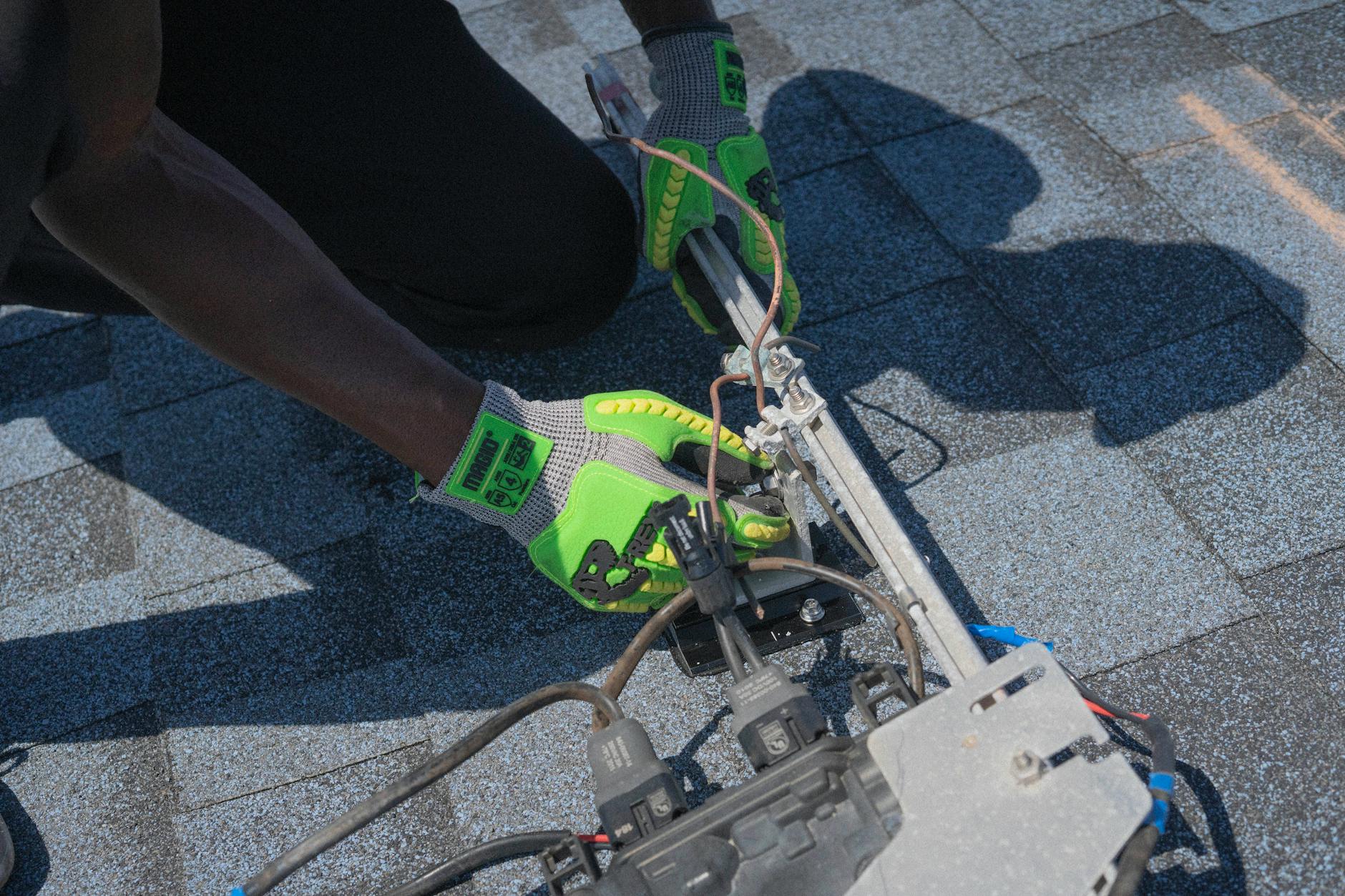 A Stone Ridge Roofing crew member, wearing safety gear, conducting a detailed storm damage inspection on a residential roof in Peabody, Massachusetts, after a winter storm.