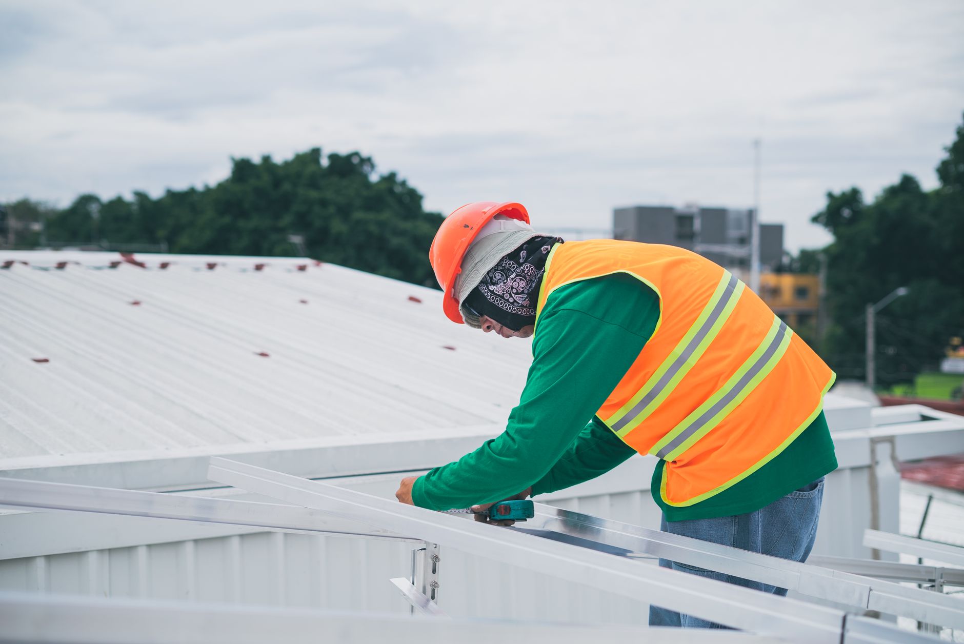 A Stone Ridge Roofing crew member inspecting a roof's ventilation system on a Danvers home, ensuring proper airflow to prevent premature shingle wear.